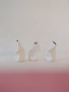 three small sculpted ceramic vases in white