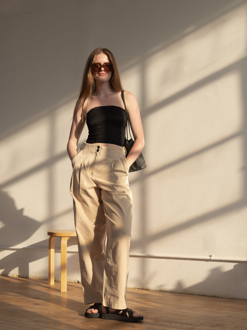 woman in black elasticated shirred tube top and khaki pants wearing brown squared-frame sunglasses