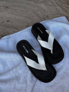 black flip-flop sandal with white leather strap